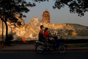 People ride a motorbike as they wear protective face masks amid the empty ancient temples usually crowded with tourists in Ayutthaya on March 30, 2020. (Reuters photo)